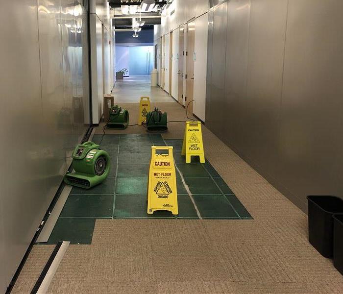SERVPRO green air movers drying commercial flooring