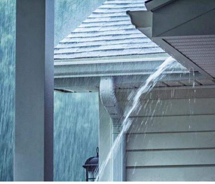 Heavy rain overflowing gutters on Lowell home